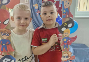 Lucjan i Oskar pozują przy foto-ramce.