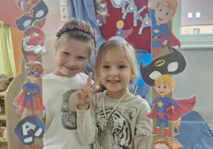 Maja i Zuzia pozują do zdjęcia z foto-ramką przygotowaną na Dzień Chłopaka.