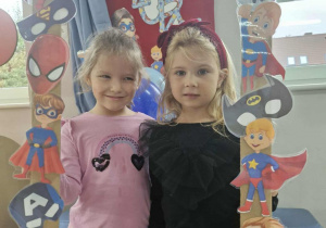 Klara i Alicja pozują do zdjęcia przy foto-ramce.