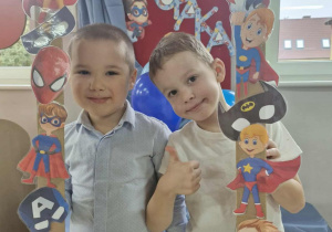 Szymek i Marcel robią sobie pamiątkowe zdjęcie w foto-ramce przygotowanej na Dzień Chłopaka.
