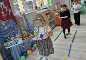 Nadia, Ala i Maja idą po torze z tarczami, na których znajdują się niebieskie piłki.