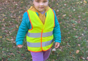 Kalina stoi na zielonej trawce w kamizelce odblaskowej.