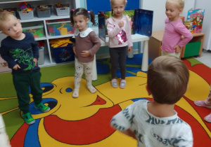 Dzieci stoją w kole podczas zabawy ruchowo-naśladowczej przy muzyce.