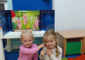 Kornelia i Marysia pozują do zdjęcia na tle teatrzyku.