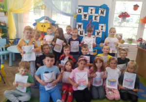 Wspólne zdjęcie na tle dekoracji z wykonanymi pracami.