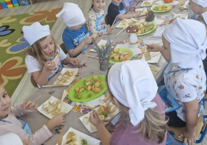 8.Przedszkolaki siedzą przy stole i jedzą przygotowane samodzielnie sałatki