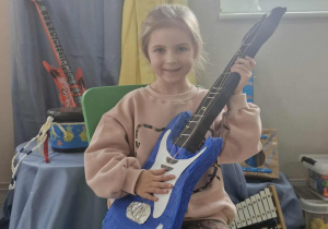 11.Oliwka pozuje do zdjęcia z gitarą elektryczną