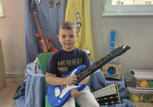 15.Oskar pozuje do zdjęcia z gitarą elektryczną