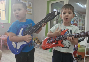 18.Szymek i Wojtuś śpiewają piosenkę trzymając w dłoniach gitary elaktryczne