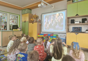 2.Dzieci siedzą na dywanie i oglądają film edukacyjny