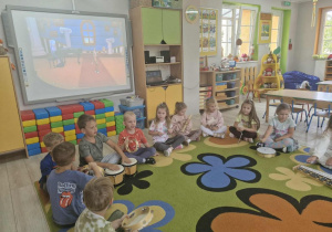 3.Przedszkolaki siedzą w kółku na dywanie. Przed nimi leżą różne instrumenty muzyczne