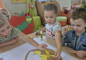 1.Wojtuś, Szymon i Marcel przyklejają koszyczek i jabłka na biały karton