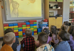 23.Przedszkolaki siedząc przy stoliczku jedzą jabłka pokrojone na ćwiartki