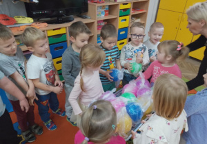 Dziewczynki podchodzą do chłopców i wręczają im upominki- piłeczki