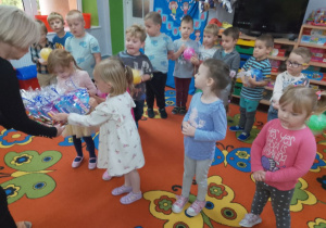 Pani wręcza drobne upominki dziewczynkom