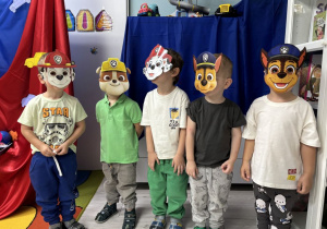 Chłopcy z grupy pszczółek ozują do zdjęcia w maskach z psiego patrolu.