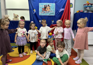 Dzieci z grupy pszczółek pozują na tle dekoracji.