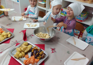 Emilia przekłada do miski pokrojone owoce.