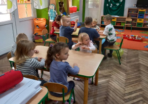 Grupka dzieci wystukuje za pomocą kasztanów dźwięki