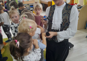 Pan przybija dzieciom pieczątkę na rączkach.