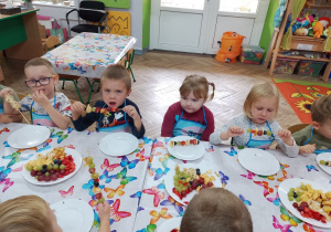 11.Grupka dzieci zjada swoje szaszłyki.