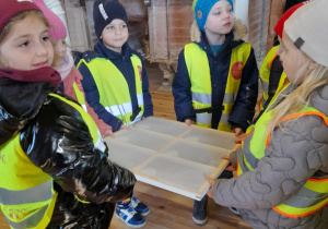 Grupka dzieci trzyma duże sito.