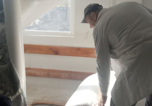 Pan wrzuca worki z mąką na lej.