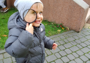 Nikodem patrzy przez szkło powiększające.