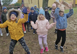 Karol, Nadia i Staś podskakują robiąc „pajacyki”.