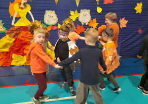 Grupka chłopców tańczy z Panią Dorotką w kole. W środku stoi Julek w przebraniu sowy.