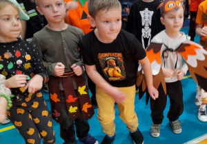 Czworo dzieci tańczy obok siebie przy muzyce.