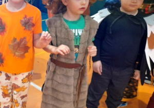 Troje dzieci tańczy obok siebie przy muzyce.