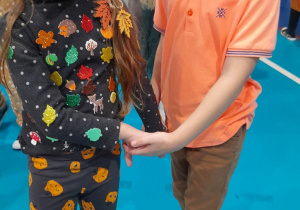 Amanda i Antek tańczą w kółeczku trzymając się za ręce.