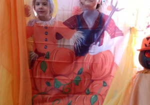 Amanda i Weronika pozują do zdjęcia w dyniowej fotobudce.