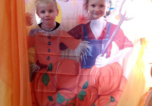 Fabian i Marcel pozują do zdjęcia w dyniowej fotobudce.