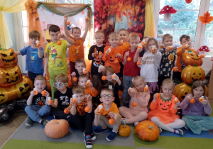 Zdjęcie grupowe na tle dekoracji z okazji Dnia Dyni z otrzymanymi upominkami