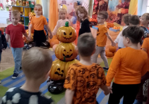 Dzieci maszerują po kole trzymając się za ręce.