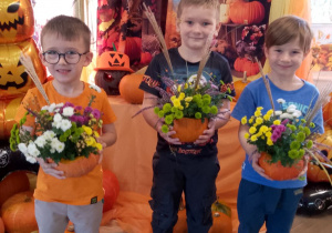 Trójka chłopców prezentuje wykonane dyniowe kompozycje.