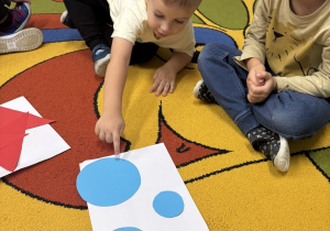 Chłopiec wskazuje największe koło na kartce.