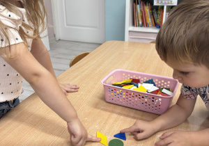 Dzieci wskazują na ułożonego pajacyka z figur geometrycznych.