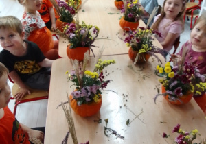 Pszczółki wzdłuż stołu z gotowymi bukietami.