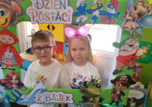 Tosia i Mikołaj pozują do zdjęcia w bajkowej fotoramce.