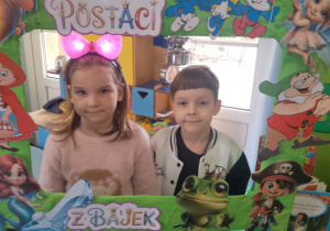 Weronika i Mateusz pozują do zdjęcia w bajkowej fotoramce.