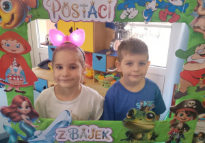 Marysia i Mikołaj pozują do zdjęcia w bajkowej fotoramce.