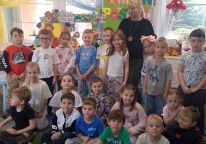 Zdjęcie grupowe z panią z biblioteki na tle dekoracji.