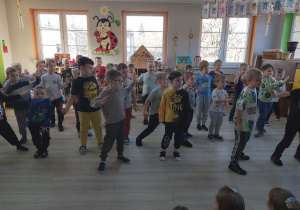 Chłopcy ze wszystkich grup wykonują "Taniec robotów" przy muzyce.