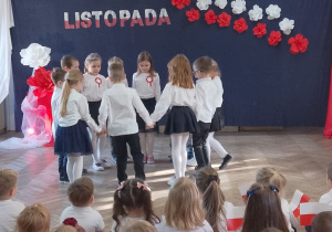 Dzieci ustawione w kole tańczą Kujawiaka.