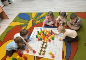 Na zdjęciu widać drzewko ułożone przez dzieci z kubeczków na macie do kodowania.