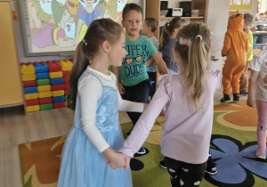 Franuś, Ola i Oliwka tańczą w kółeczku do bajkowej muzyki.