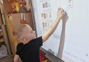 Lucjan rozwiązuje zadanie na tablicy multimedialnej.